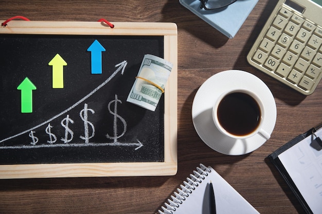 Gráfico de crecimiento del dólar en la pizarra con objetos comerciales