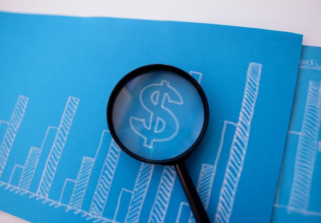 Gráfico de crecimiento financiero dibujado con lupa closeup
