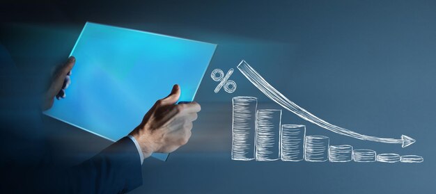 Gráfico dibujado de monedas y un signo de porcentaje. hombre sosteniendo una tableta