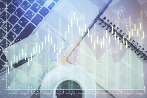 Gráfico do mercado de ações e computador de visão superior sobre o fundo da mesa Dupla exposição Conceito de educação financeira