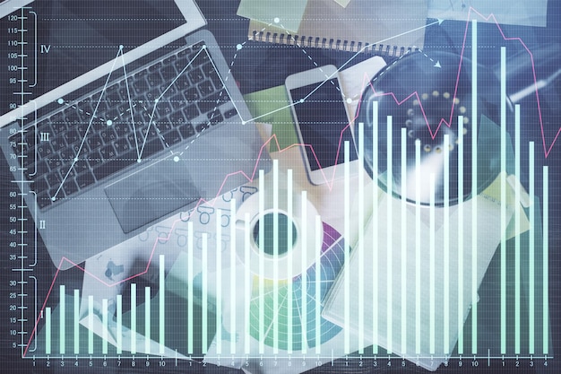 Gráfico do mercado financeiro e computador de visão superior no plano de fundo da área de trabalho Conceito de investimento de exposição múltipla