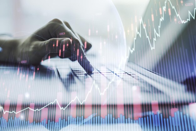 Gráfico financeiro criativo abstrato com mapa do mundo e com as mãos digitando no laptop no fundo forex e conceito de investimento Multiexposição