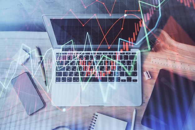 Gráfico financiero dibujo colorido y tabla con computadora en el fondo Doble exposición Concepto de mercados internacionales