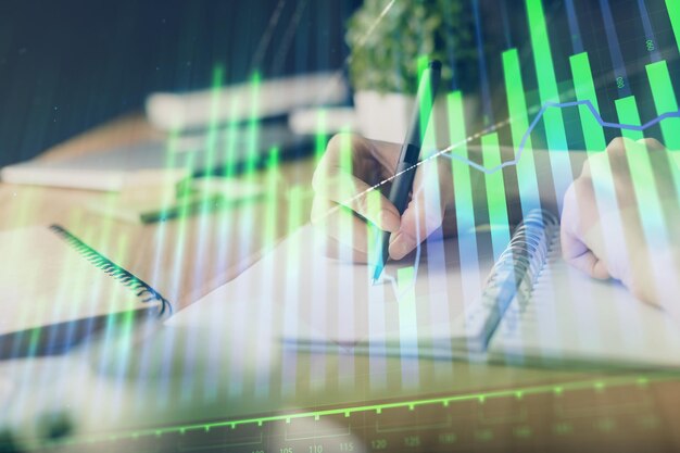 Gráfico financiero de divisas dibujado sobre manos tomando notas de fondo Concepto de investigación Exposición múltiple