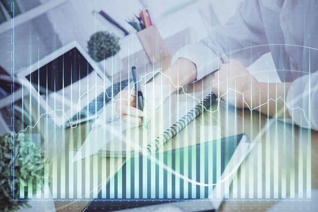 Gráfico financiero mostrado en la mano de la mujer tomando notas de fondo Concepto de investigación Doble exposición