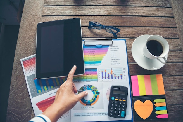 Gráfico y gráfico de documentos financieros de negocios de portátiles de oficina en una mesa de madera con una taza de café Computadora portátil plana en el escritorio de la oficina No hay maqueta de gráficos de gráficos de negocios de personas en el espacio de trabajo de negocios