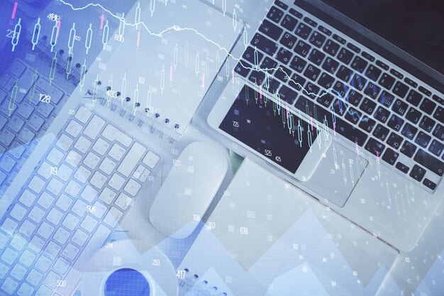 Gráfico de mercado financiero y computadora de vista superior en el fondo del escritorio Concepto de inversión de exposición múltiple