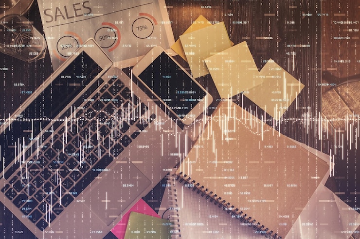 Foto gráfico del mercado financiero y computadora con vista superior en el fondo del escritorio concepto de inversión de exposición múltiple