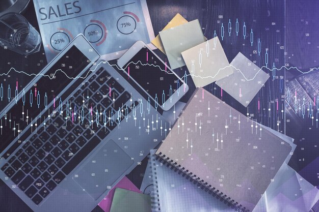 Gráfico del mercado financiero y computadora con vista superior en el fondo del escritorio Concepto de inversión de exposición múltiple