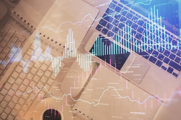 Gráfico del mercado financiero y computadora con vista superior en el fondo del escritorio Concepto de inversión de exposición múltiple