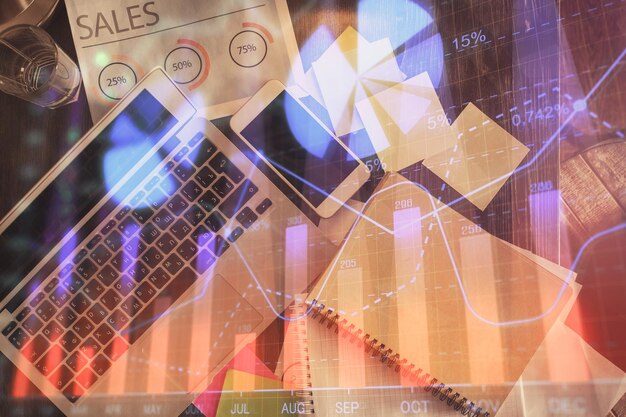 Gráfico del mercado financiero y computadora con vista superior en el fondo del escritorio Concepto de inversión de exposición múltiple