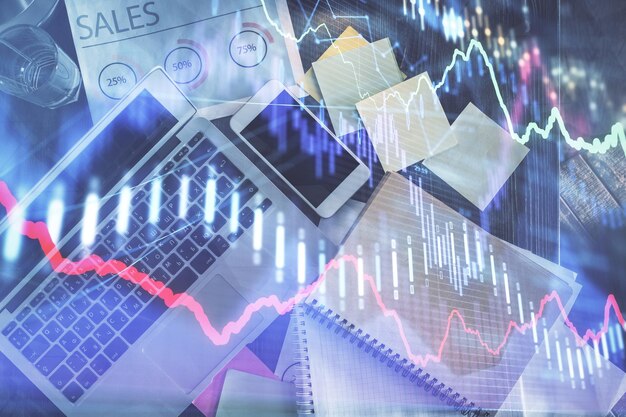 Gráfico del mercado financiero y computadora con vista superior en el fondo del escritorio Concepto de inversión de exposición múltiple