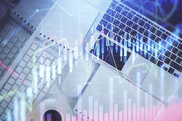 Gráfico del mercado financiero y vista superior de la computadora en el fondo del escritorio Concepto de inversión de exposición múltiple