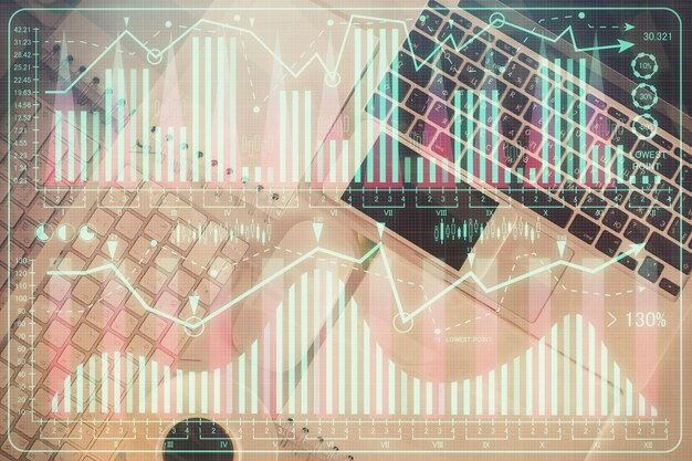 Gráfico del mercado financiero y vista superior de la computadora en el fondo del escritorio Concepto de inversión de exposición múltiple