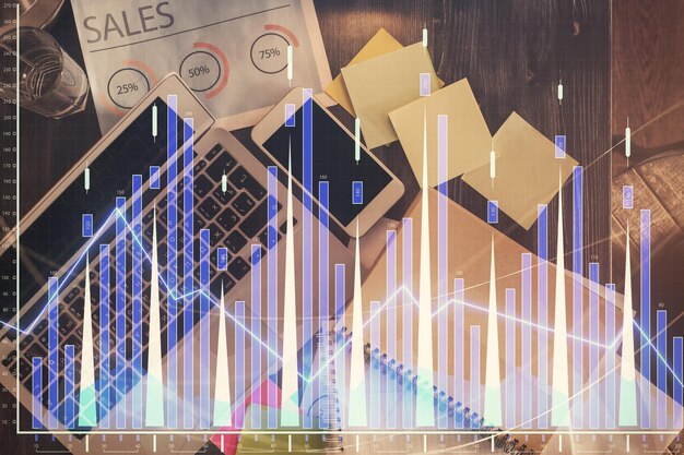 Gráfico del mercado financiero y vista superior de la computadora en el fondo del escritorio Concepto de inversión de exposición múltiple