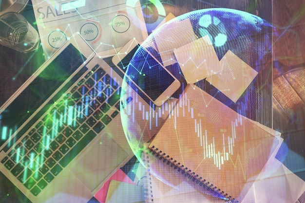 Gráfico del mercado financiero y vista superior de la computadora en el fondo del escritorio Concepto de inversión de exposición múltiple