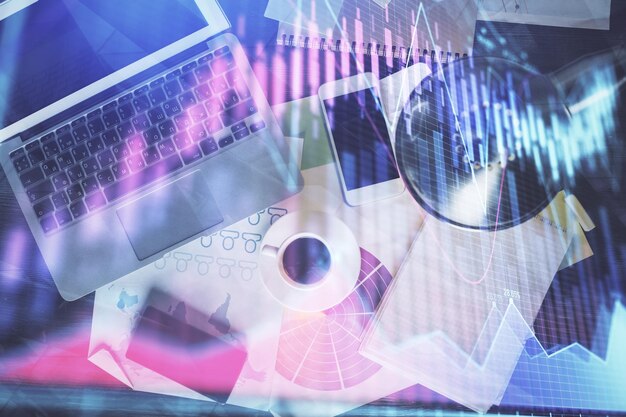 Gráfico del mercado financiero y vista superior de la computadora en el fondo del escritorio Concepto de inversión de exposición múltiple