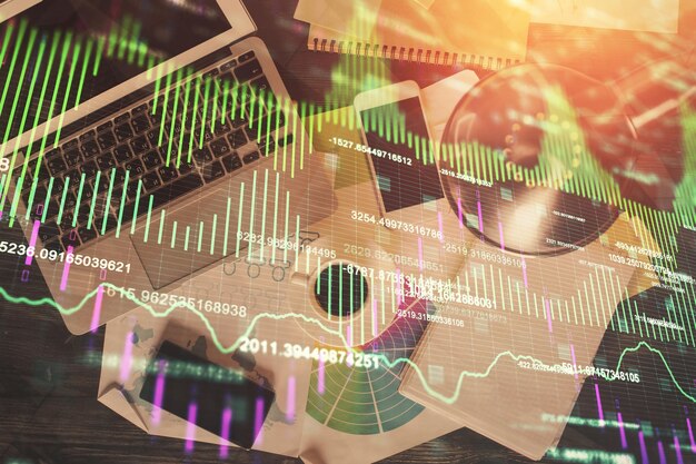 Gráfico del mercado financiero y vista superior de la computadora en el fondo del escritorio Concepto de inversión de exposición múltiple