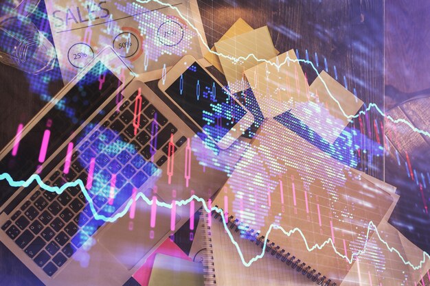 Gráfico del mercado financiero y vista superior de la computadora en el fondo del escritorio Concepto de inversión de exposición múltiple