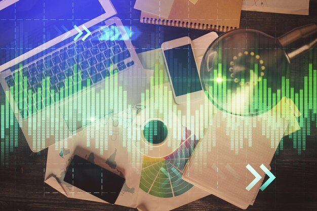 Gráfico del mercado financiero y vista superior de la computadora en el fondo del escritorio Concepto de inversión de exposición múltiple