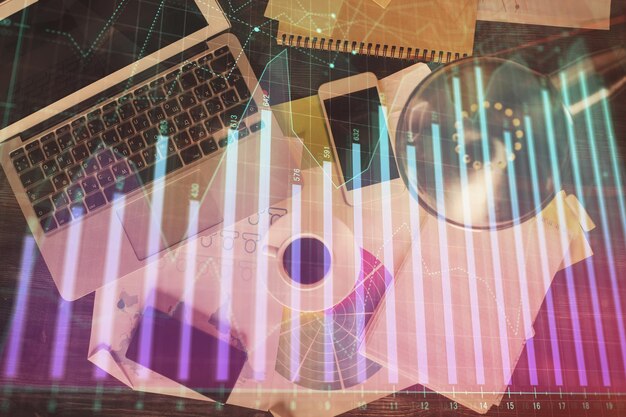 Gráfico del mercado financiero y vista superior de la computadora en el fondo del escritorio Concepto de inversión de exposición múltiple