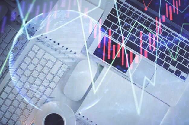 Gráfico del mercado financiero y vista superior de la computadora en el fondo del escritorio Concepto de inversión de exposición múltiple