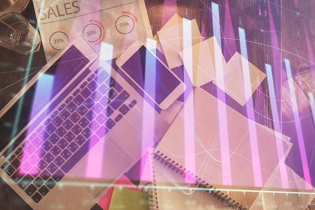 Gráfico del mercado financiero y vista superior de la computadora en el fondo del escritorio Concepto de inversión de exposición múltiple