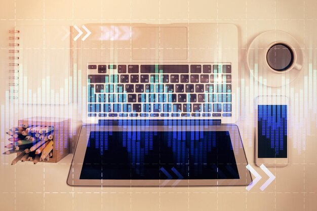 Gráfico del mercado de valores y computadora de vista superior en el fondo de la mesa Concepto de exposición múltiple de análisis financiero