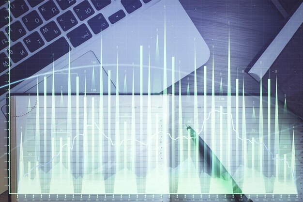 Gráfico del mercado de valores y computadora de vista superior en el fondo de la mesa Concepto de exposición múltiple de educación financiera