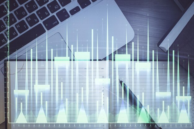Gráfico del mercado de valores y computadora de vista superior en el fondo de la mesa Concepto de exposición múltiple de educación financiera