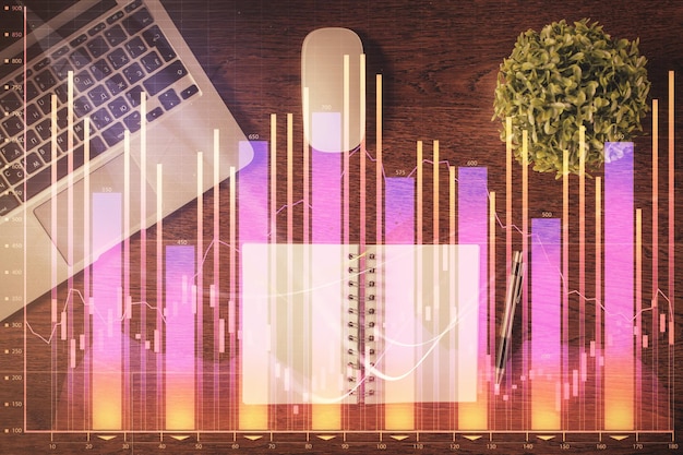 Gráfico del mercado de valores y computadora con vista superior en el fondo de la mesa Doble exposición Concepto de educación financiera
