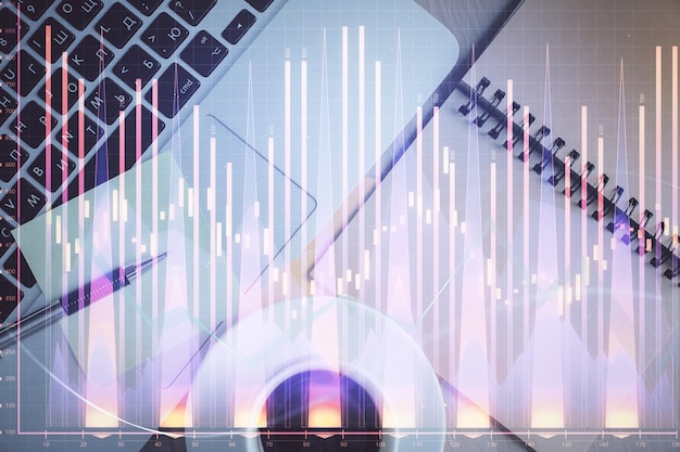 Gráfico del mercado de valores y vista superior de la computadora en el fondo de la tabla Doble exposición Concepto de educación financiera