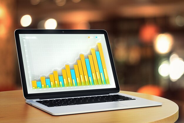 Gráfico de negocios en la pantalla del portátil en la mesa de madera