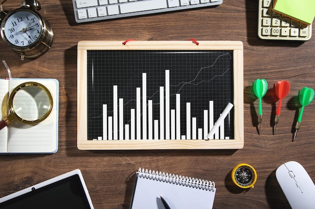 Gráfico de negocios en pizarra con objetos de negocios