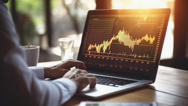 Gráficos y diagramas en la pantalla del portátil mientras el analista del mercado financiero trabaja en la computadora portátil