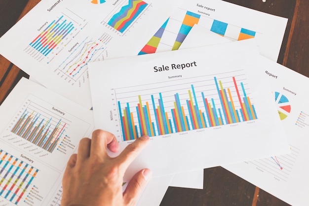 Gráficos e tabelas financeiras na mesa de madeira