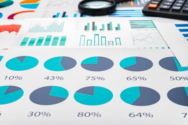 Gráficos de negocios y lupa en mesa