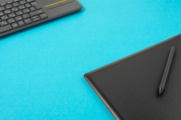 Grafiktablett und Tastatur auf einem blauen Hintergrund.