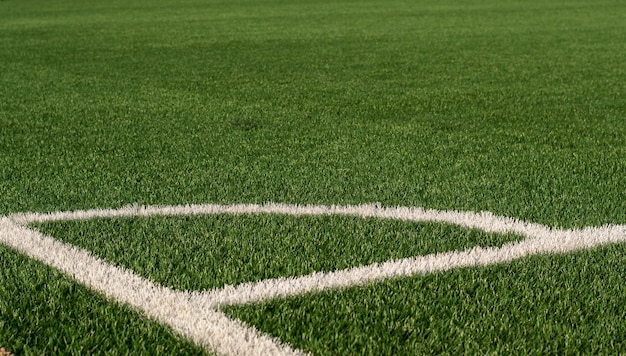 Grama verde artificial e linhas de borda branca Relva artificial para campo de futebol Campo de futebol em um estádio ao ar livre Foco seletivo