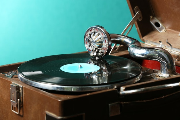 Gramofone com disco de vinil na mesa sobre fundo verde