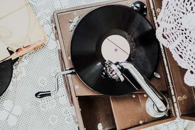 Foto gramofone com um disco de vinil na toalha de mesa de malha