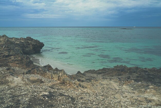 Foto gran acantilado con horizonte nublado y mar claro y tranquilo