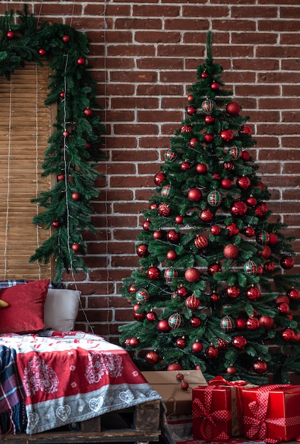 Gran árbol de navidad con bolas rojas de navidad en el interior de la habitación