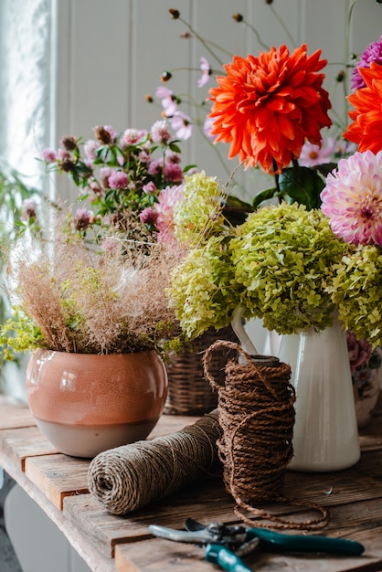 Gran arreglo floral bouquet en la floristería de escritorio en el fondo de un muro de hormigón