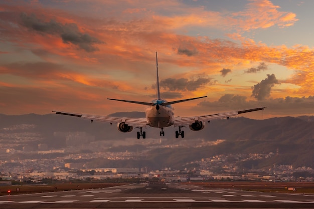 Gran avión aterrizando en el aeropuerto internacional de Osaka Itami durante la puesta de sol Japón