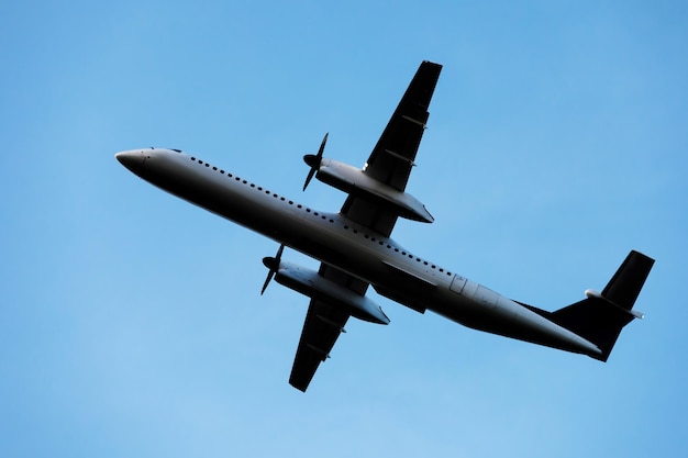 Un gran avión moderno vuela en el cielo una vista desde abajo desde el suelo hasta el vientre del avión