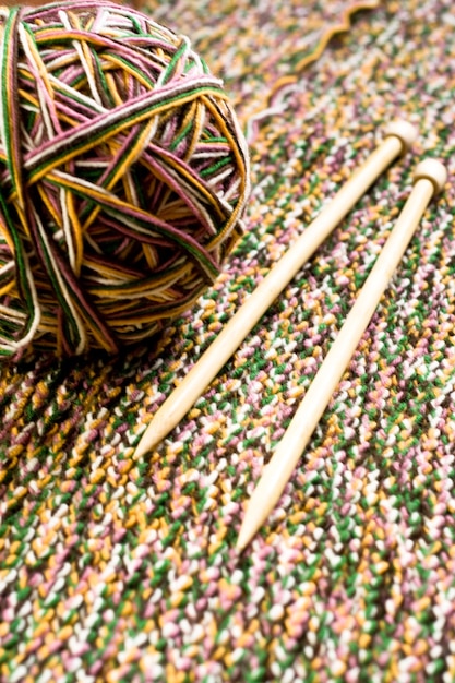 Gran bola de hilo de colores agujas de tejer de madera y tejido de punto