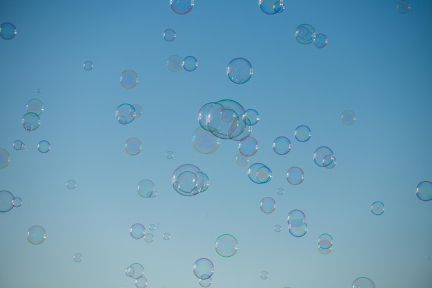 Gran burbuja volando sobre el cielo azul Enormes burbujas de jabón coloridas vuelan sobre el fondo del cielo nublado