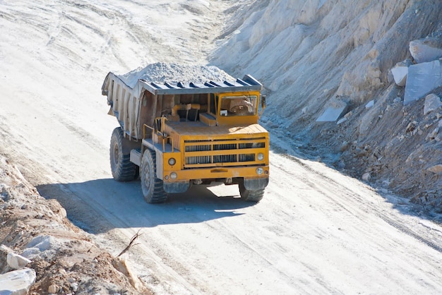 Gran camión minero transporta mineral en una cantera de mármol