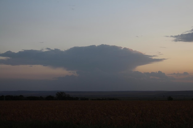 Un gran campo con una gran nube en el cielo.